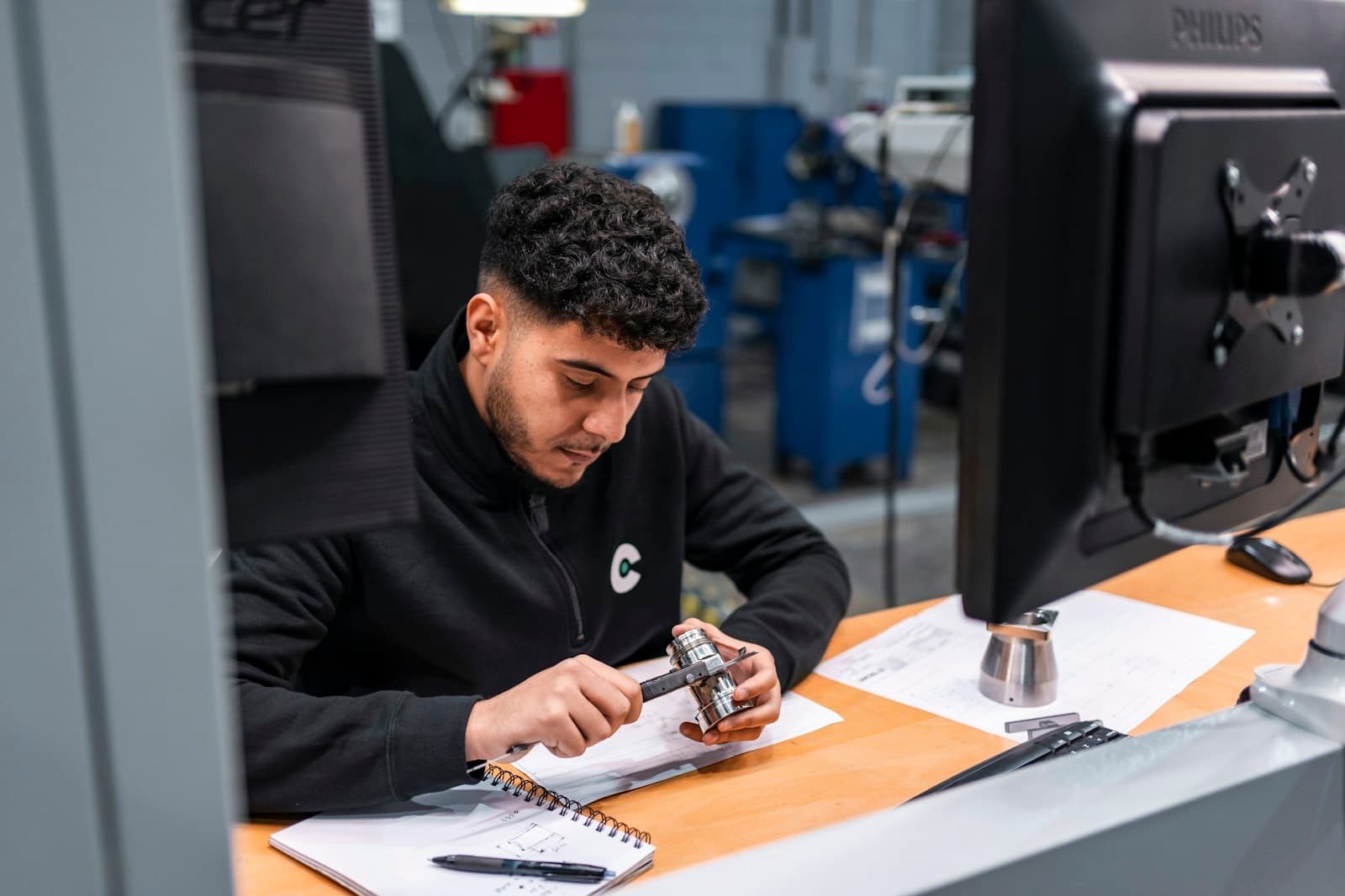 Machinist measuring a part over drawings
